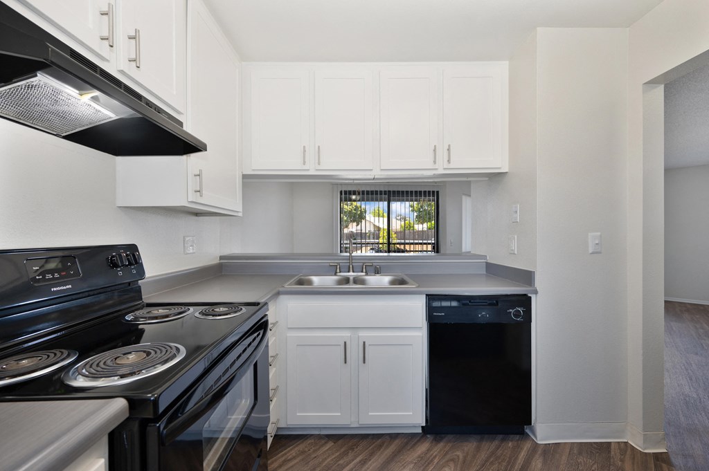 a 1-bedroom apartment kitchen with white cabinets and black appliances