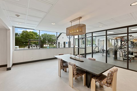 A modern dining room with a long table and chairs.