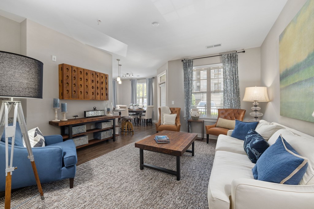 A living room with a blue sofa, a wooden coffee table, and a painting on the wall.