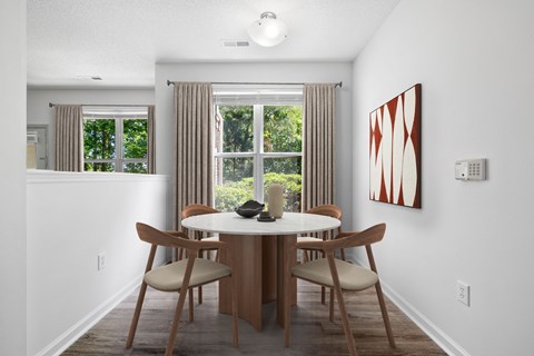 A dining room with a table and chairs.
