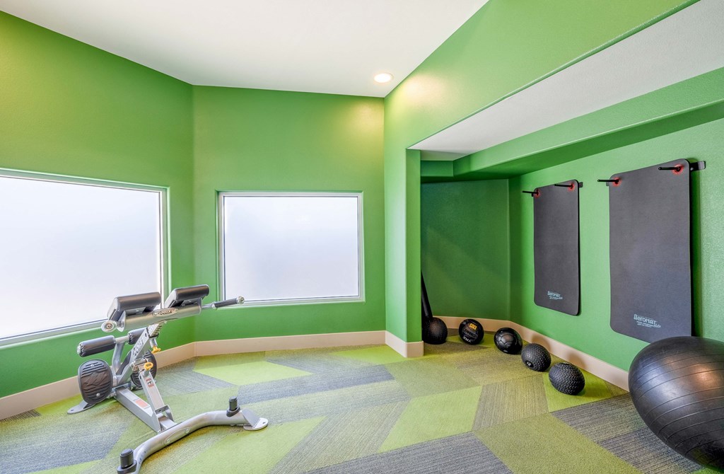 a gym with green walls and exercise equipment