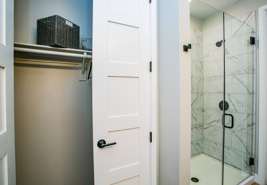 a bathroom with a white door and a glass shower stall