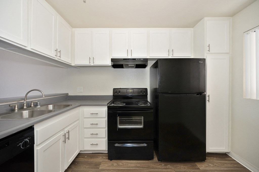 a 2-bedroom apartment kitchen with black appliances and white cabinets