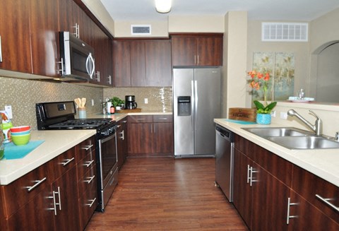a kitchen with wooden cabinets and stainless steel appliances