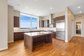 a kitchen with hardwood floors and a large center island with a white countertop