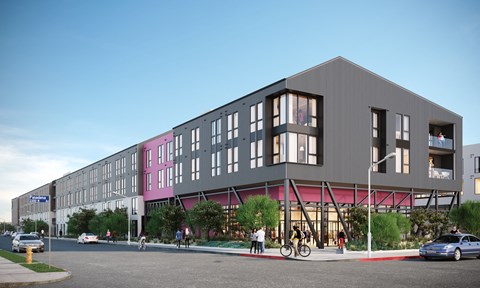 A modern building with a grey facade and pink accents is surrounded by a street scene with cars, bicycles, and pedestrians.