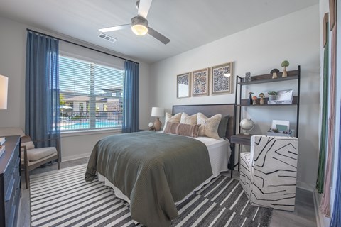 A bedroom with a large bed and a ceiling fan.
