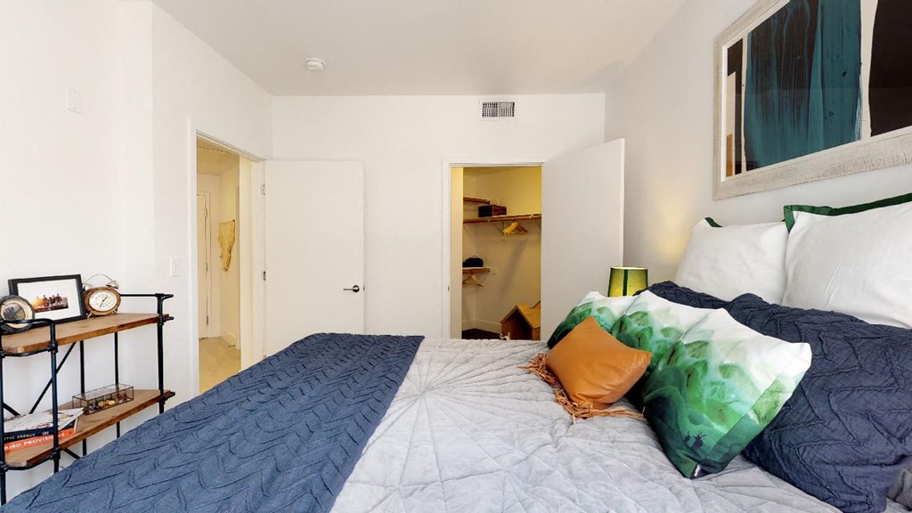 a bedroom with a bed and a desk with a clock