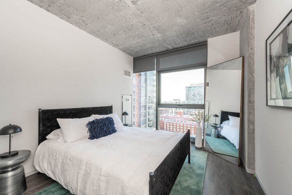 a bedroom with a bed and a large window