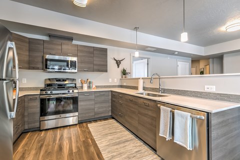 A modern kitchen with a stainless steel refrigerator and wooden cabinets.