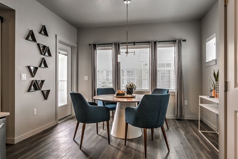 A dining room with a table and chairs.