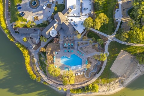 An aerial view of a resort with a swimming pool and a large building.