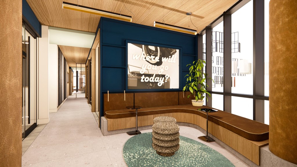 a lobby with a blue wall and a bench with a plant and a tv