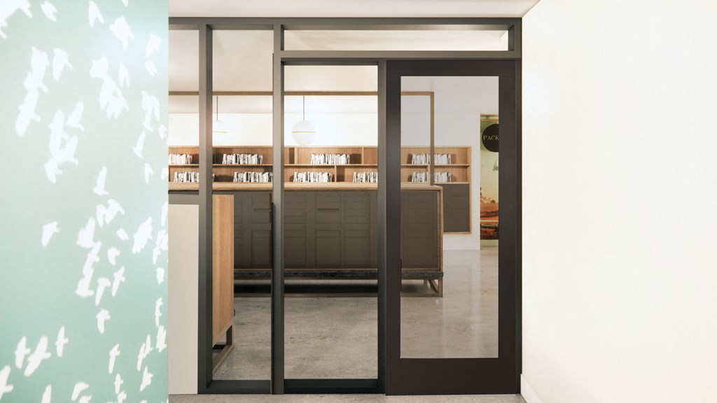 a view of a library from a hallway with glass doors