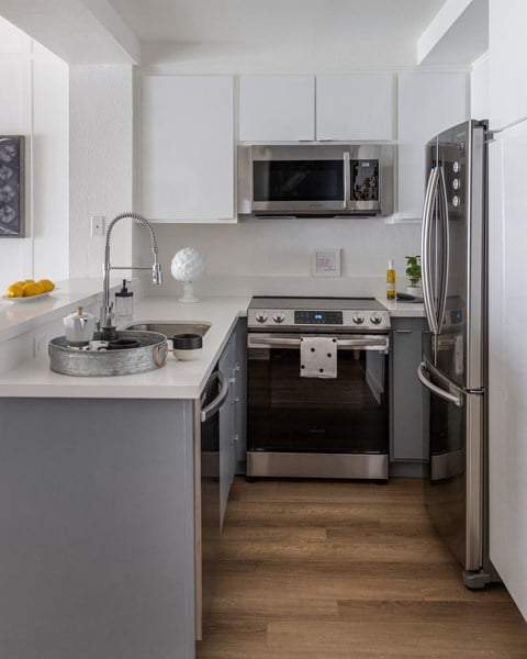 a kitchen with stainless steel appliances and a sink and a refrigerator