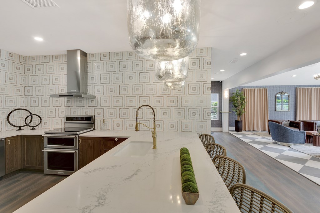 A modern kitchen with a long white island in the middle.