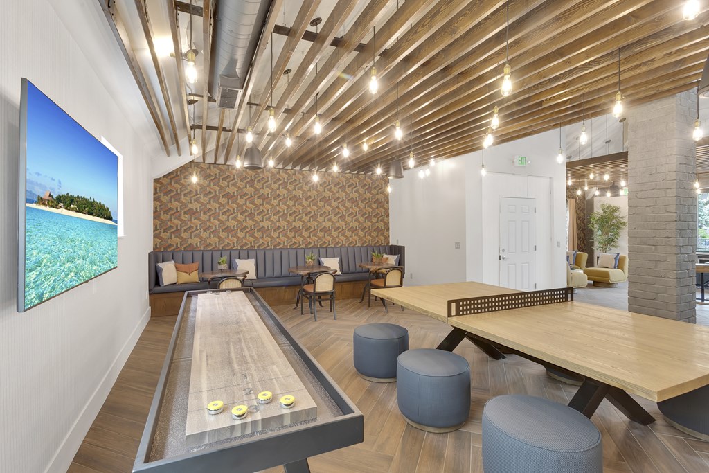 A room with a shiny wooden floor and a long table with a shiny wooden top.
