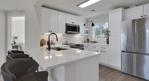 All white renovated kitchen with kitchen island and new appliances Reonovated kitchen at Palomino Park Apartments