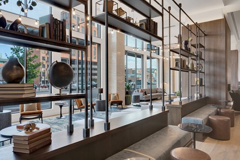 A modern living room with a long bookshelf and a view of the city.