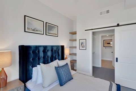 A bedroom with a large bed and two pictures on the wall.