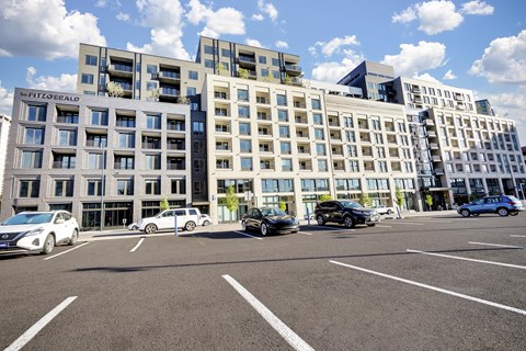 A parking lot with cars and apartment buildings in the background.