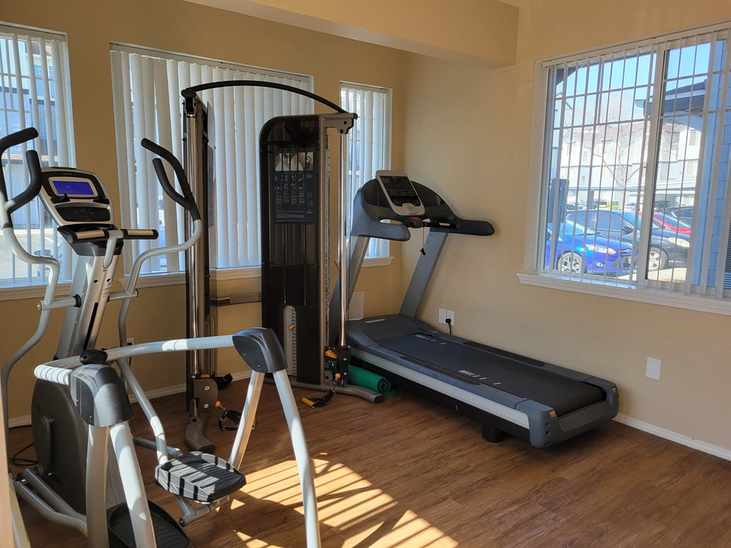 A fitness center with a treadmill and elliptical