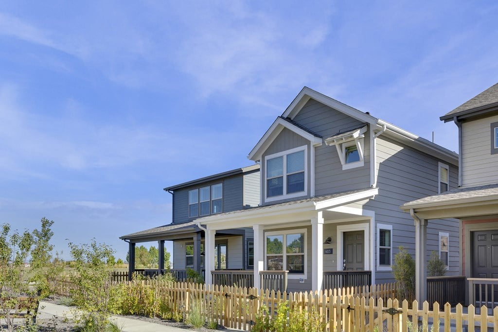 a blue house with white trim and a wooden fence