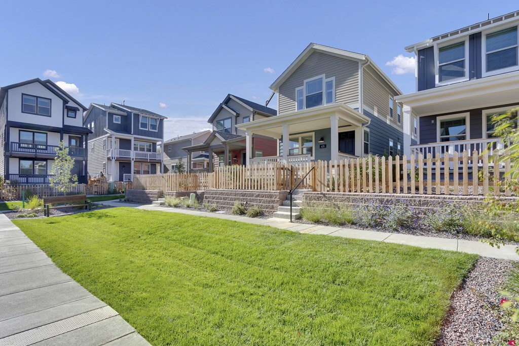 a row of houses with a yard and a sidewalk