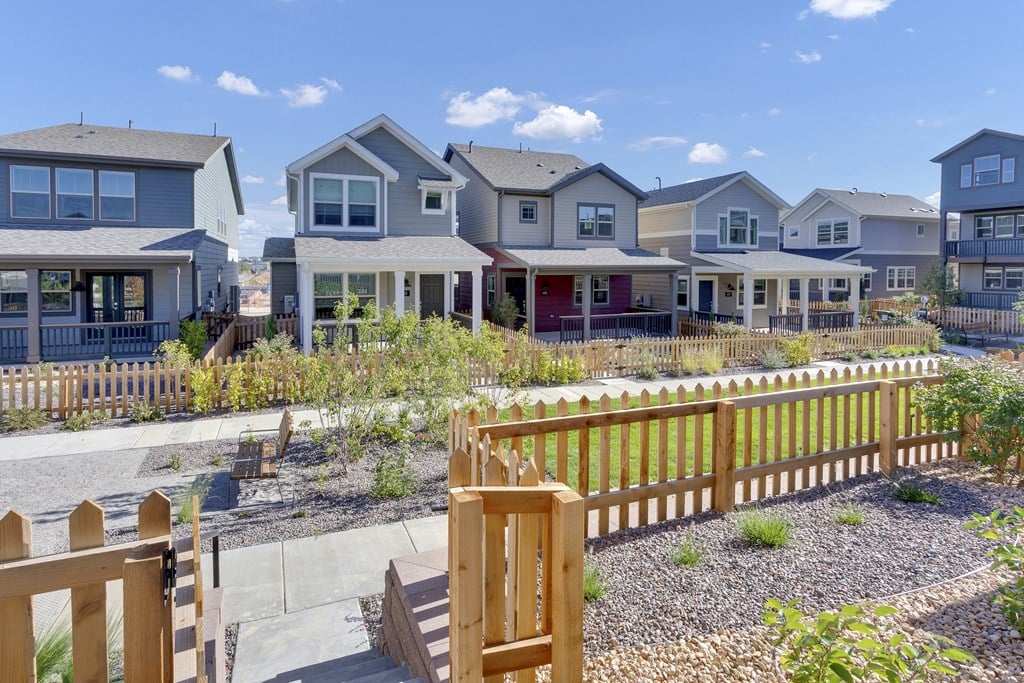a row of houses with a yard and a wooden fence