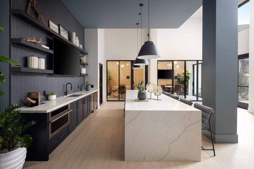 a large kitchen with a marble counter top and black cabinets