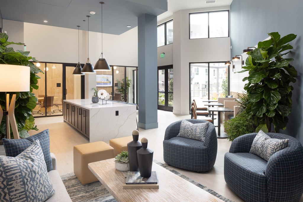 a living room with blue and white furniture and a kitchen