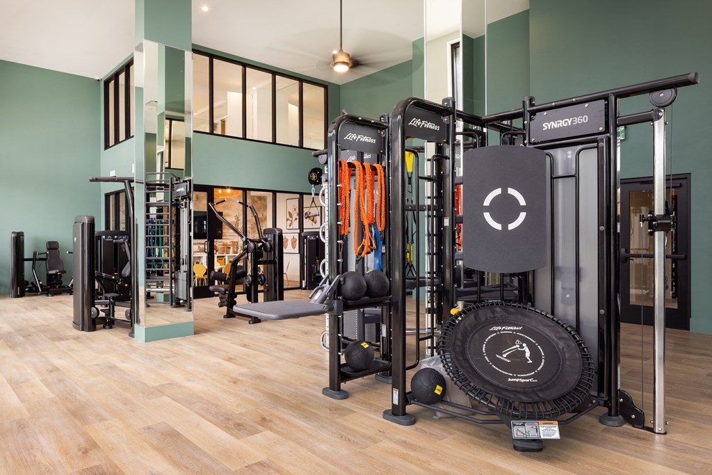 a gym with weights and other gym equipment on a wooden floor