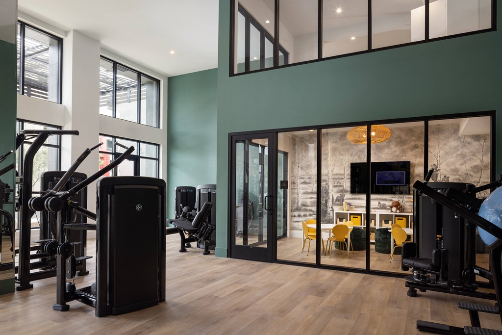 a gym with gym equipment and glass doors