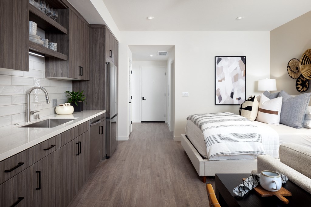 a bedroom with a bed and a sink in a room