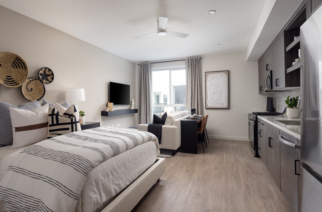 a bedroom with a bed and a desk and a living room