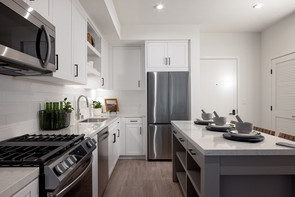 a kitchen with white cabinets and a stainless steel refrigerator