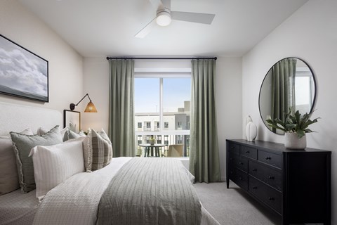 a bedroom with a bed and a dresser and a window