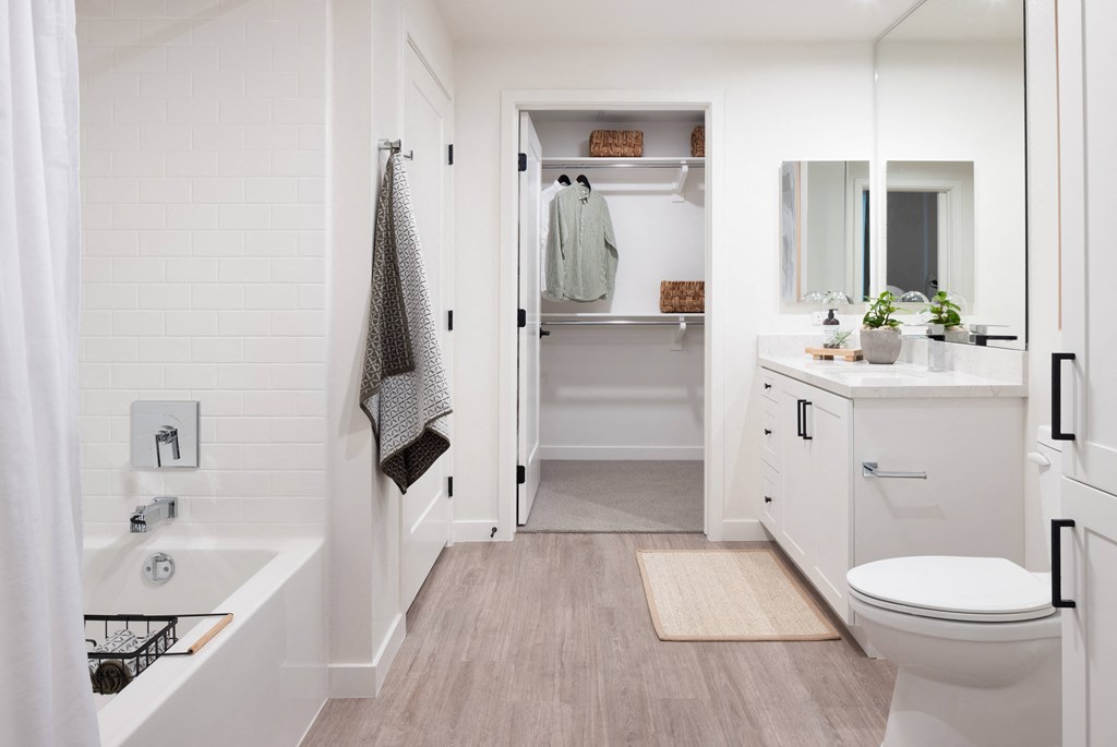 a white bathroom with a toilet and a tub and a sink