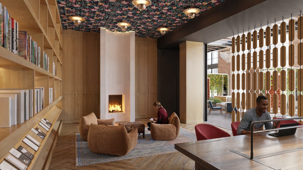 A man is sitting at a table in a room with a fireplace.