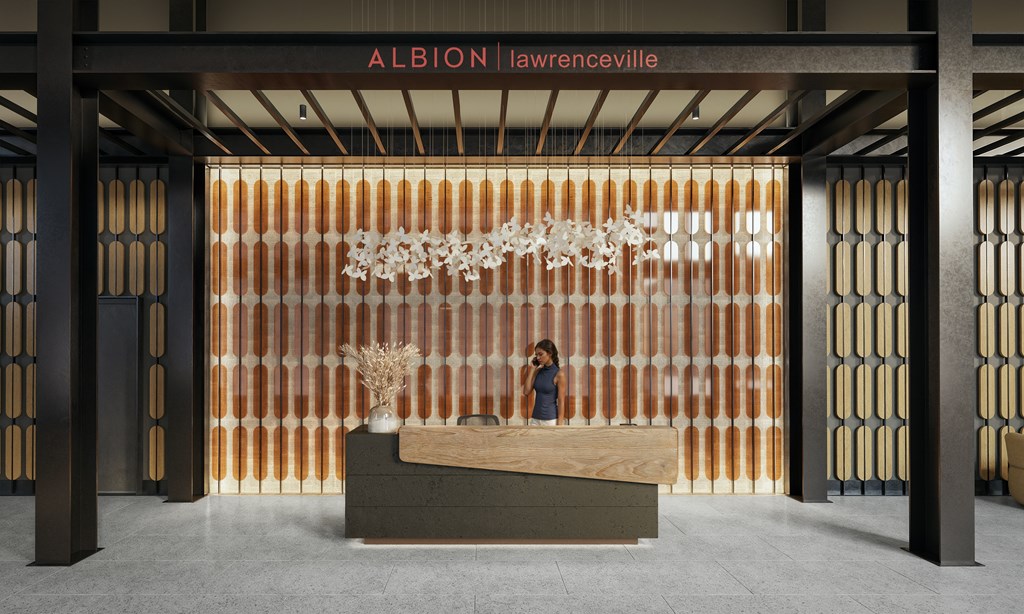 A woman stands behind a reception desk in a building with the sign "Albion Lawrenceville" on the top.
