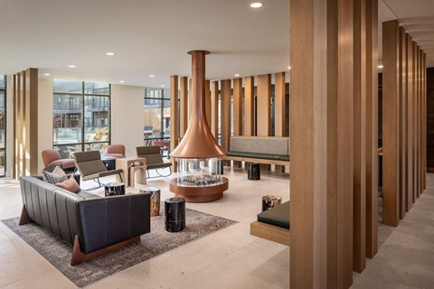 A modern living room with a fireplace and a long wooden column.
