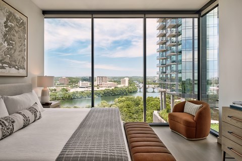 A bedroom with a large bed and a view of the city.