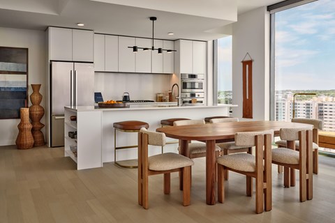A modern kitchen with a dining table and chairs.