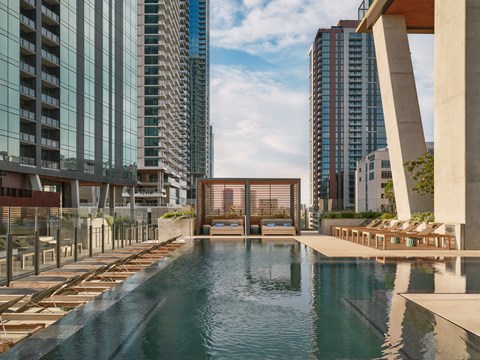 A pool in the middle of a city surrounded by buildings.