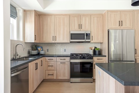 A kitchen with wooden cabinets and a black countertop.