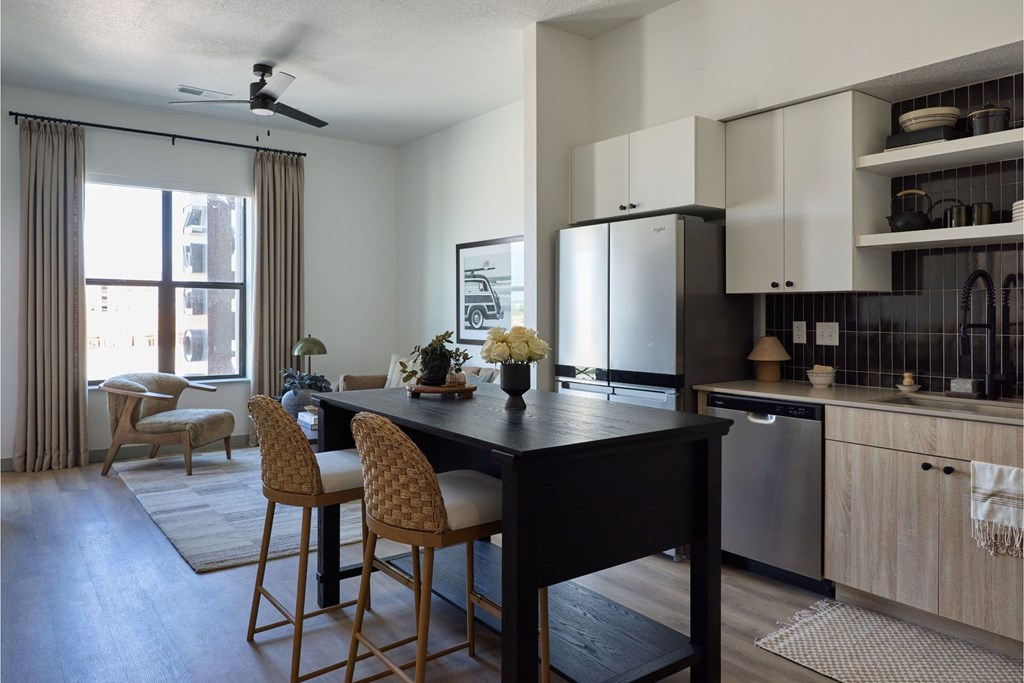 A kitchen with a table and chairs in front of a window.