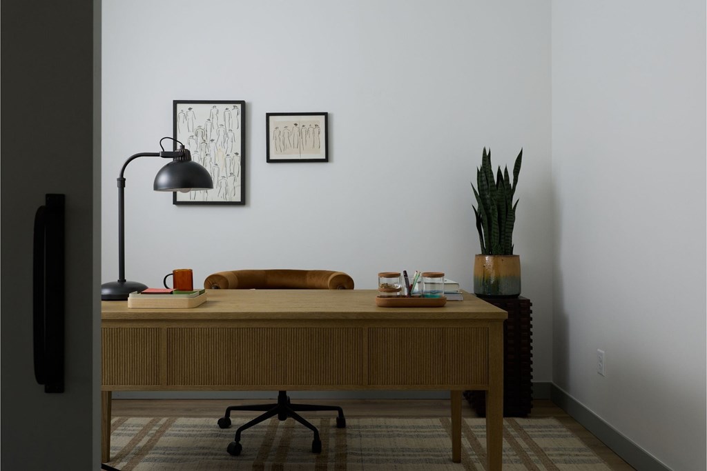 A desk with a lamp and a plant on it.