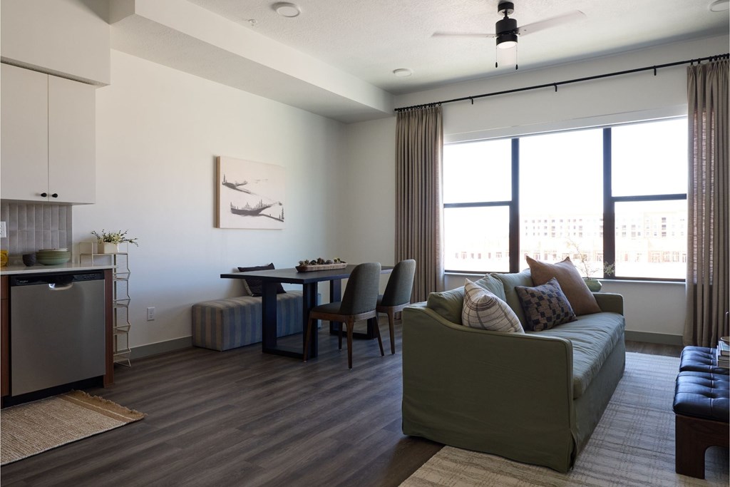 A living room with a green couch and a dining table.
