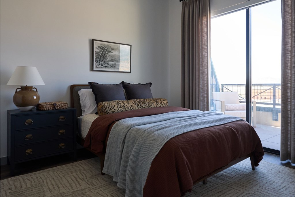 A bedroom with a large bed and a view of the outside.