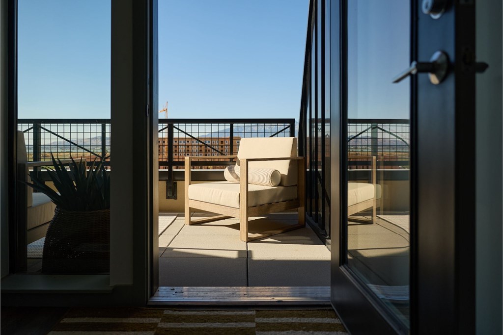 A view of a balcony through a glass door.